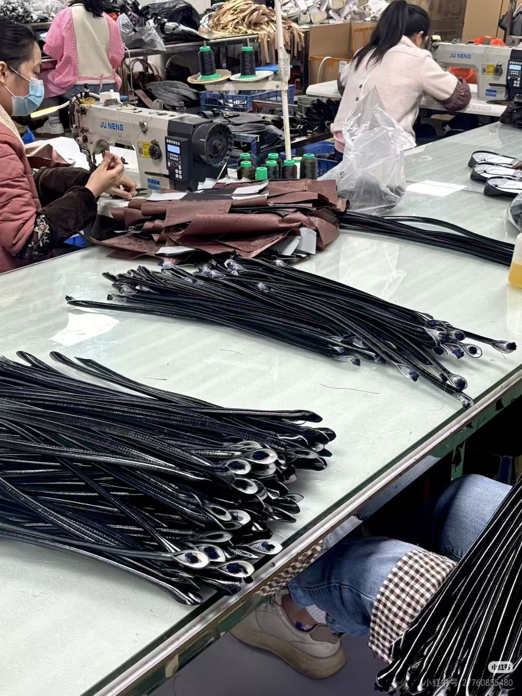 Workers sewing bag straps and components